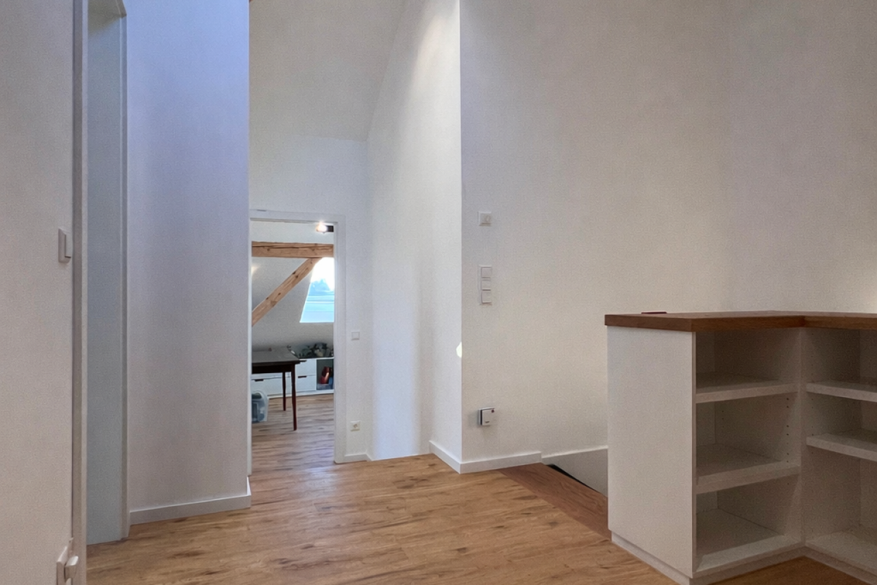 Heller Flur mit Holzregal und Tür